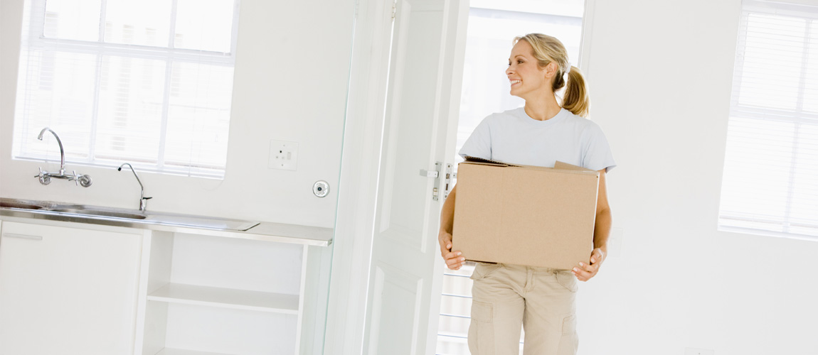 Lady walking into home with moving box