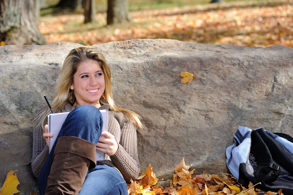 Female student studying outside in the fall