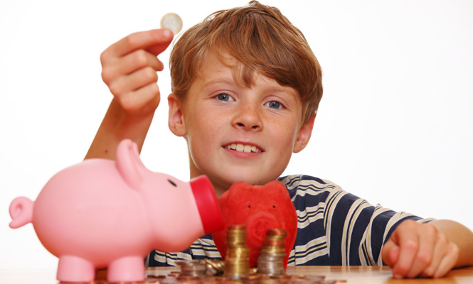 Boy putting change in his piggy bank