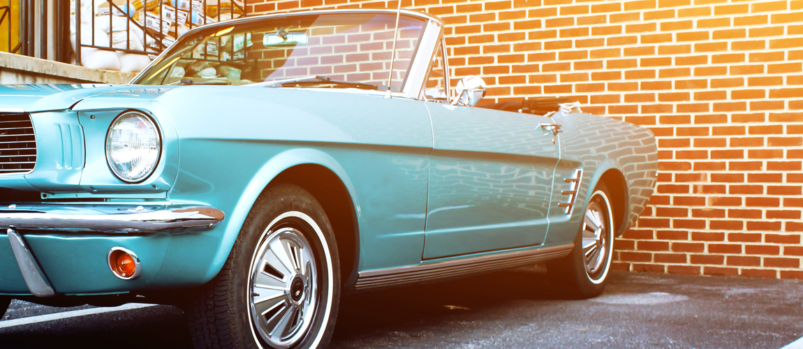 Classic car parked by a brick wall