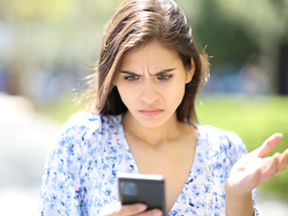 Woman looking at her phone, confused