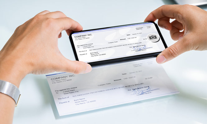 person taking photo of their check to deposit with their phone via mobile deposit