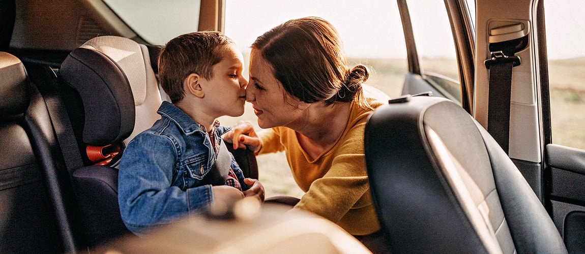 Mother getting son ready for car ride