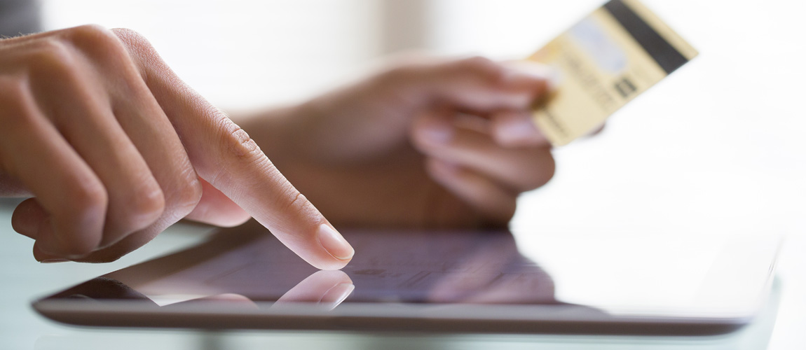 person paying with a credit card on an iPad