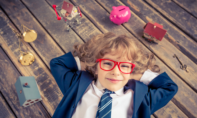 Young boy laying on floor with a piggy bank, house, key around him