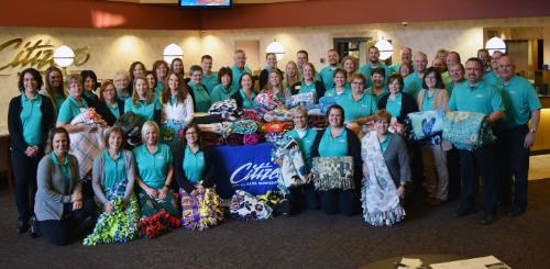 Bank employees smiling holding blankets